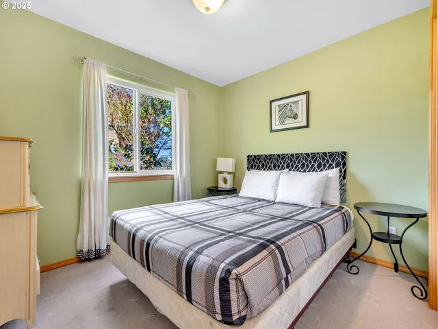 a bedroom with a bed lamp and a window