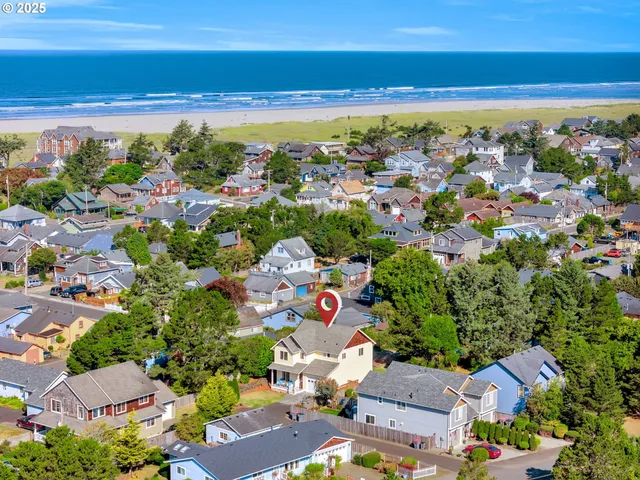 an aerial view of residential houses with outdoor space and ocean view