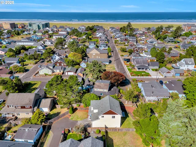 an aerial view of a city with lots of residential buildings and ocean view in back