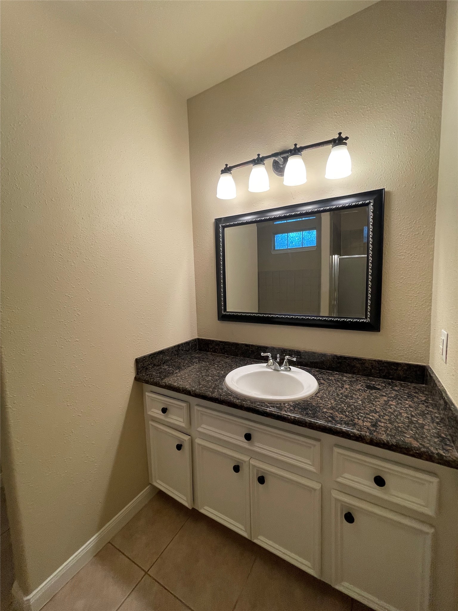 10607 Mills Way Houston, TX 77070 - Photo 15 of 17 a bathroom with a granite countertop sink and a mirror