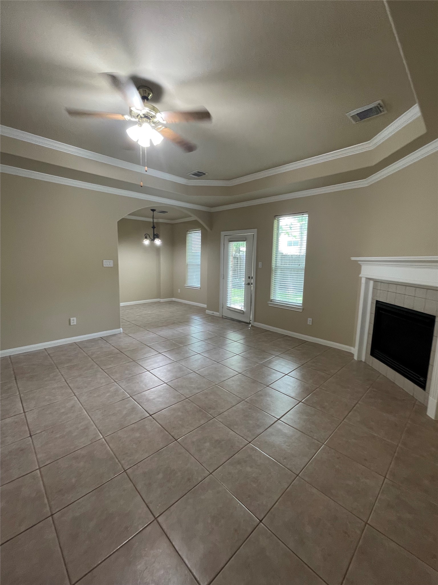 10607 Mills Way Houston, TX 77070 - Photo 4 of 17 a view of an empty room with a fireplace and chandelier fan
