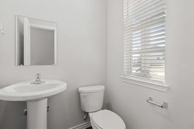 a bathroom with a toilet sink and mirror