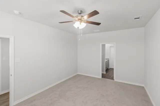 a view of an empty room with a ceiling fan