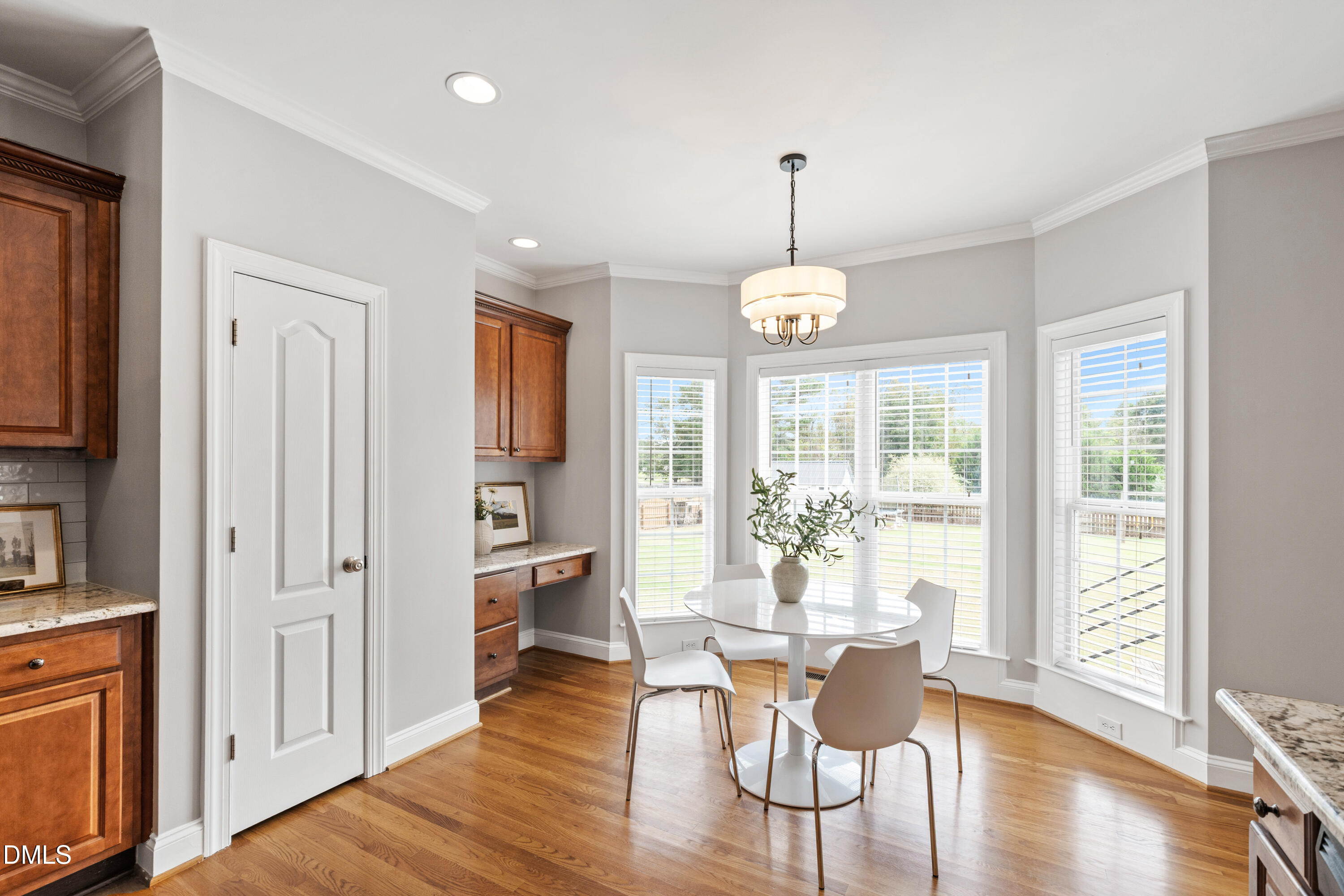 7753 Pegram Street Willow Spring, NC 27592 - Photo 20 of 54 a dining room with wooden floor a chandelier a glass table and chairs