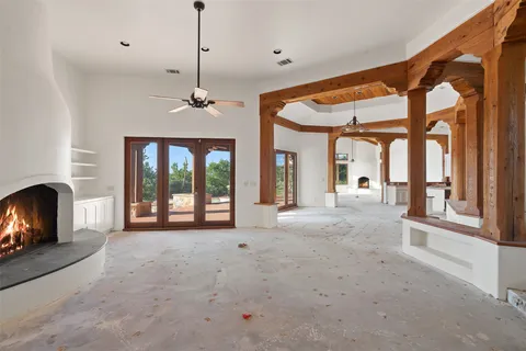 a living room with furniture large windows and a fireplace