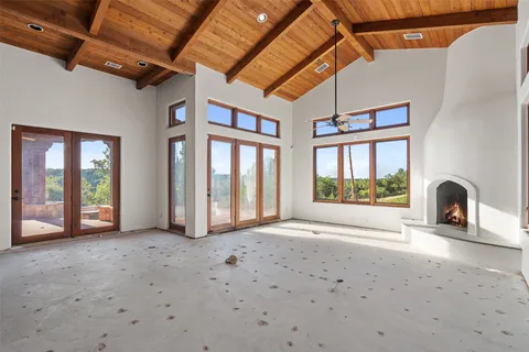 a large bedroom with a bed and a large window with the balcony view