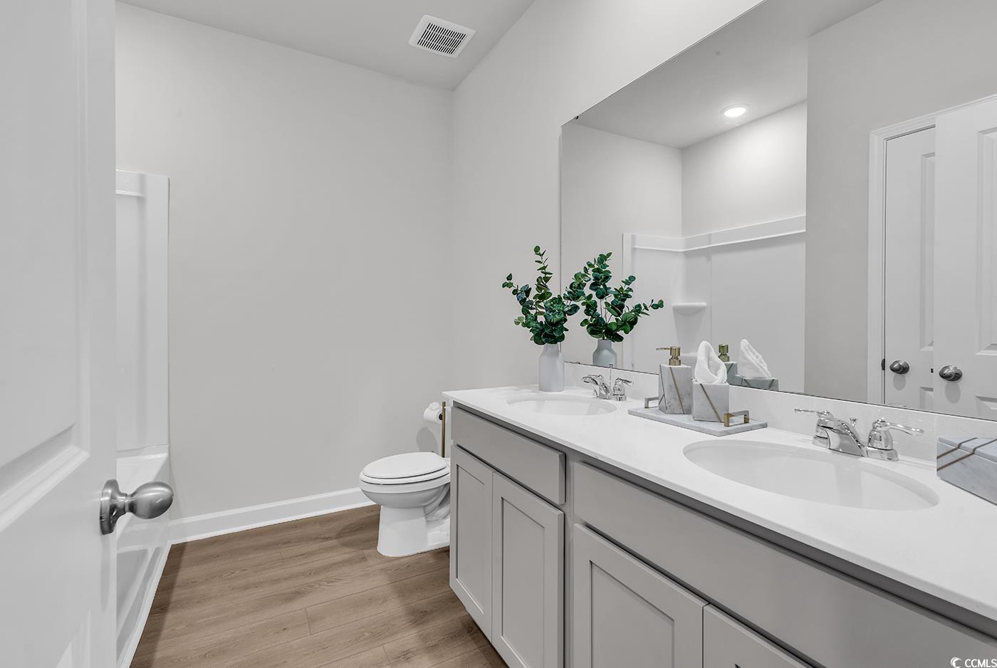3104 Palma Way Myrtle Beach, SC 29579 - Photo 6 of 40 Bathroom featuring double vanity, light wood-type flooring, and shower / washtub combination