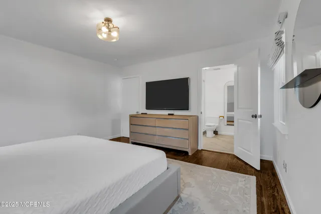 a bedroom with a bed and flat screen tv