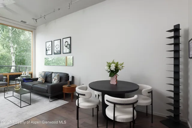 a living room with furniture a window and a potted plant