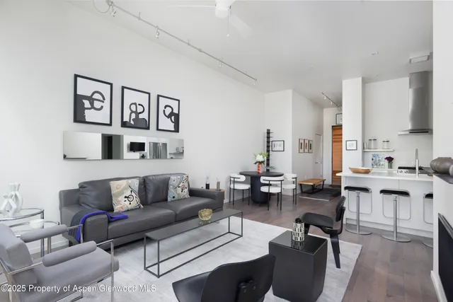 a living room with furniture kitchen view and a large window