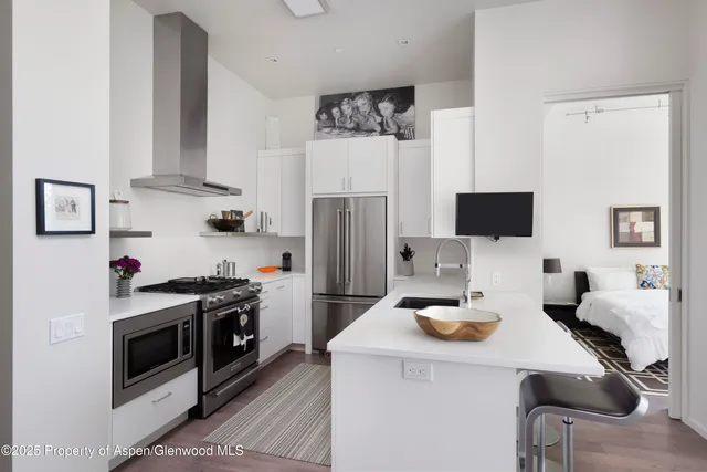 a kitchen with stainless steel appliances a stove a sink and a refrigerator