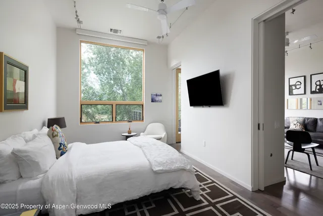 a bedroom with a bed and a flat tv screen on the dresser