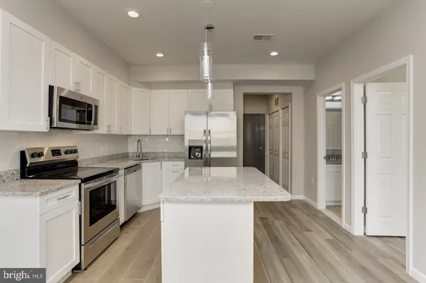 a kitchen with a sink a counter top space stainless steel appliances and cabinets