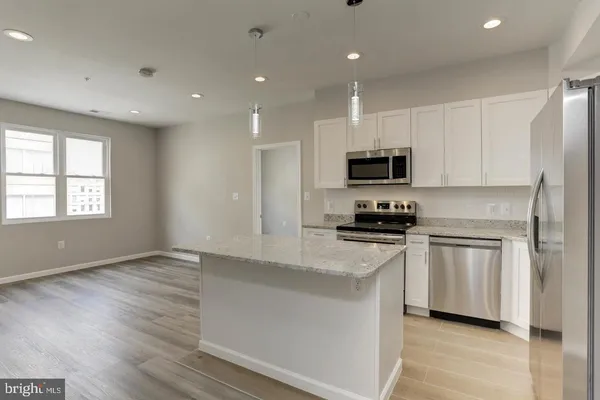 a kitchen with granite countertop white cabinets and black appliances
