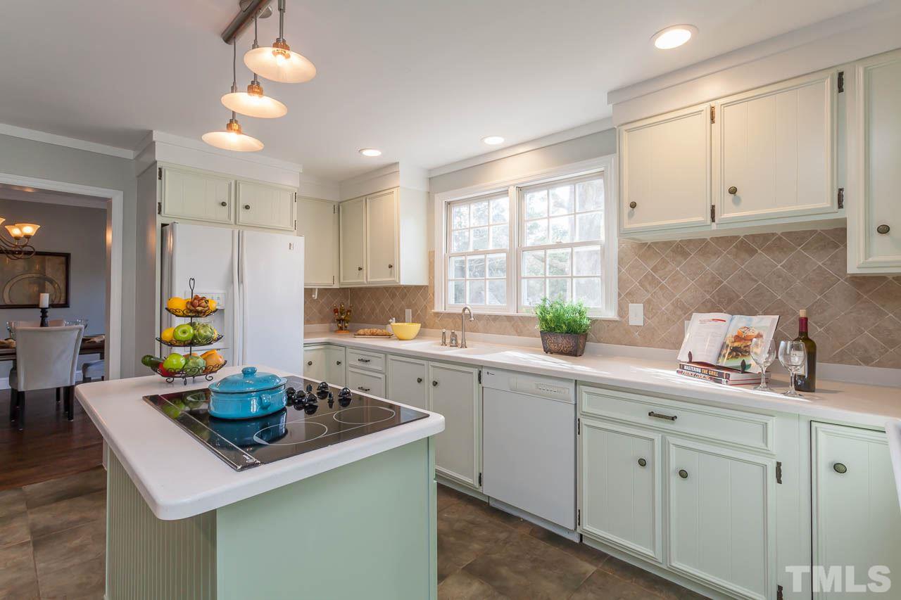 2333 Mt Vernon Church Road Raleigh, NC 27614 - Photo 5 of 24 a kitchen with kitchen island granite countertop a sink a stove cabinets and a window