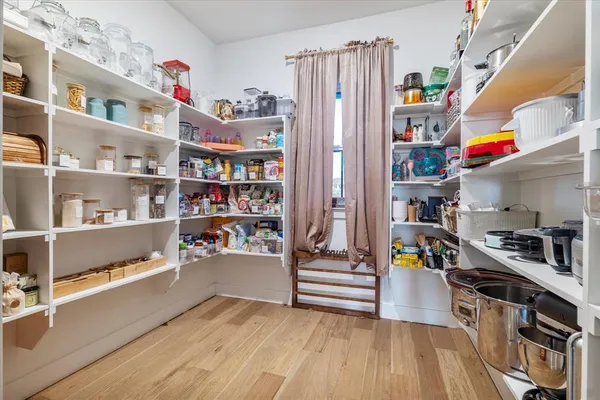 a view of a bedroom with a bed and wooden floor
