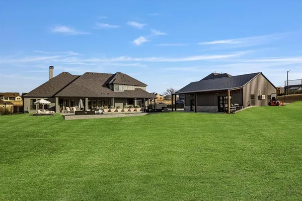 a view of a house with a big yard and large trees