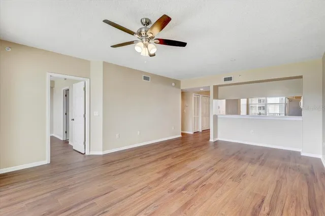 a view of empty room with wooden floor and window