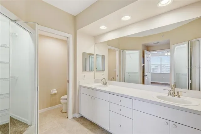 a spacious bathroom with a double vanity sink mirror and toilet