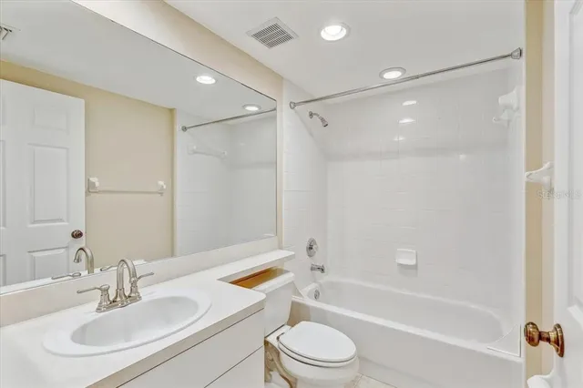 a bathroom with a bathtub shower sink vanity and toilet