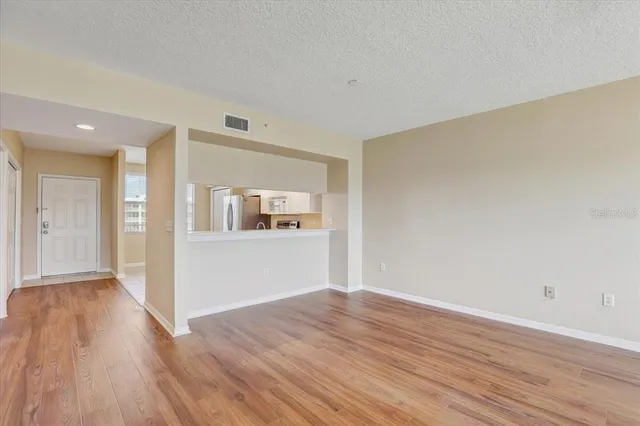a view of empty room with wooden floor