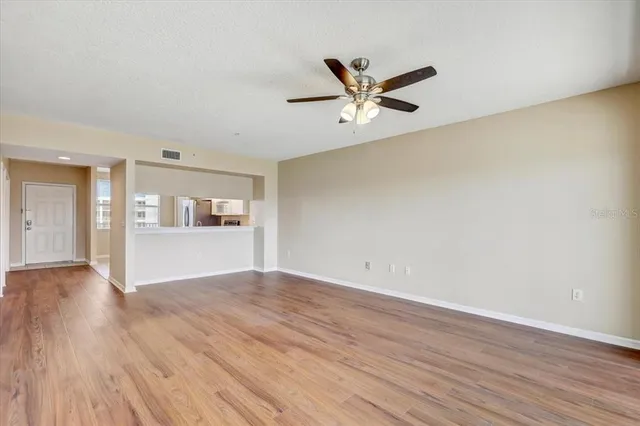 a view of empty room with wooden floor and window