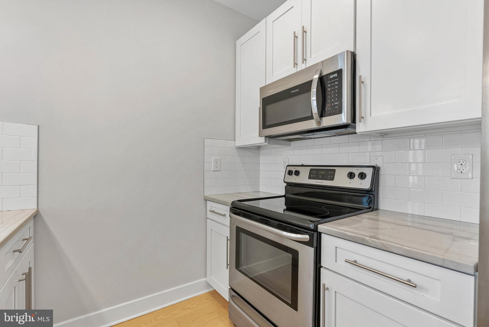 1238 North 6th Street, Unit B Philadelphia, PA 19122 - Photo 4 of 21 a kitchen with stainless steel appliances white cabinets and a stove top oven