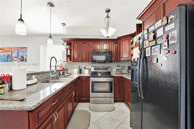 a kitchen with granite countertop a sink stainless steel appliances and cabinets