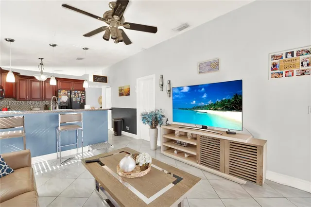 a living room with furniture a floor to ceiling window and a flat screen tv