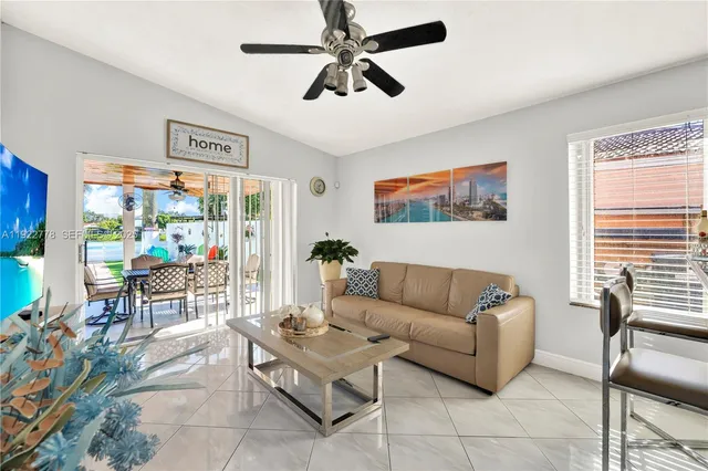 a living room with furniture a flat screen tv and a window