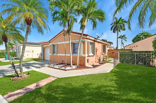 a view of a house with backyard and sitting area