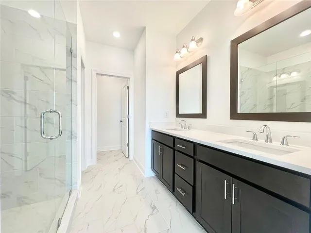 a spacious bathroom with a double vanity sink mirror and shower