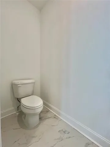 a white toilet sitting next to a white sink