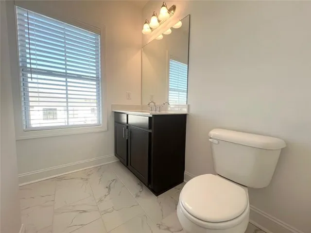 a bathroom with a toilet a sink and a mirror