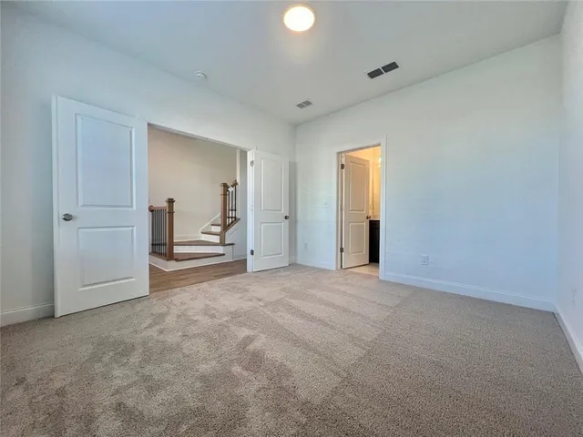 an empty room with closet and windows