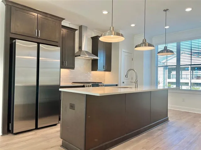 a kitchen with stainless steel appliances granite countertop a refrigerator a sink and a stove