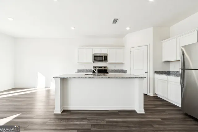a kitchen with stainless steel appliances granite countertop a sink stove and refrigerator