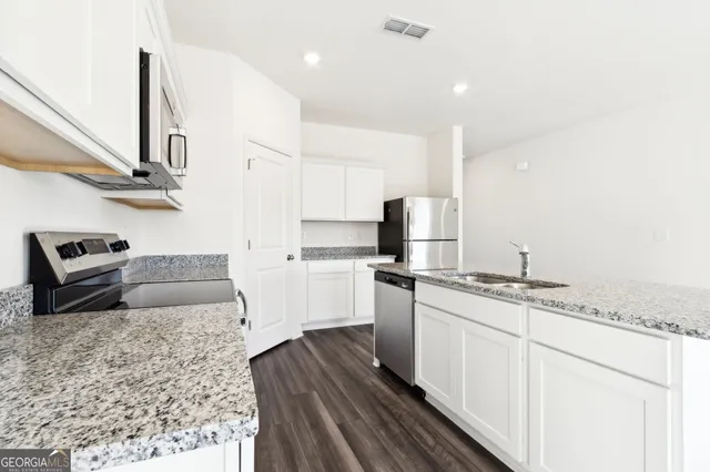 a kitchen with stainless steel appliances granite countertop a sink stove and refrigerator