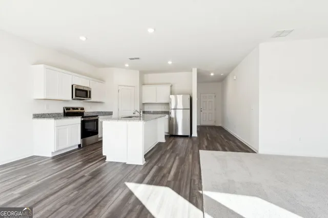 a kitchen with a refrigerator and a stove top oven