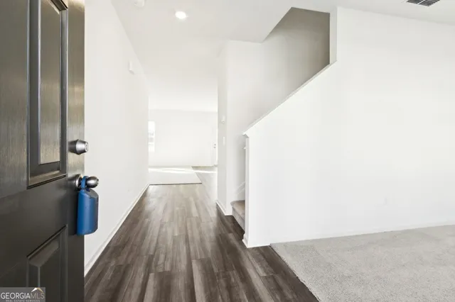 a view of a hallway with wooden floor