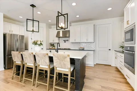 a dining room with furniture a chandelier and wooden floor