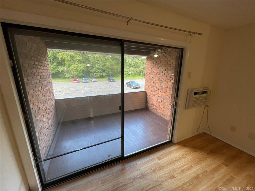 565 Talcottville Road, Unit 2B7 Vernon, CT 06066 - Photo 3 of 10 a view of an empty room with wooden floor and a window