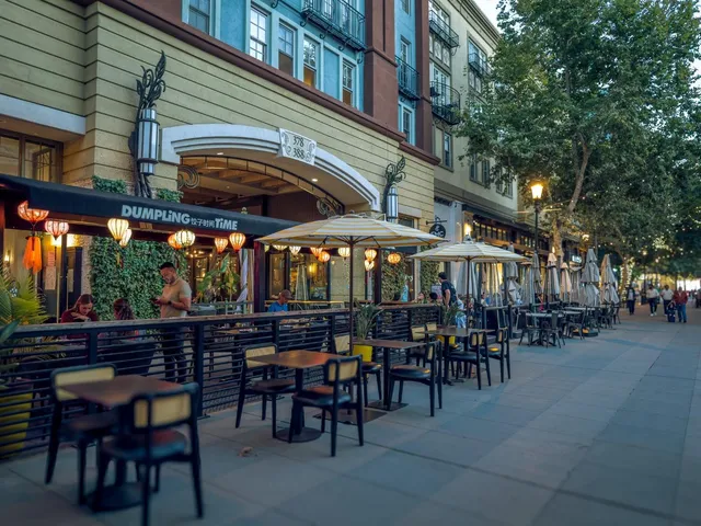 a view of a big building with table and chairs