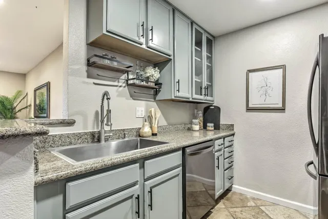 a kitchen with stainless steel appliances granite countertop a sink stove and cabinets