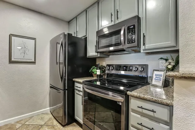 a kitchen with stainless steel appliances granite countertop a refrigerator stove and microwave
