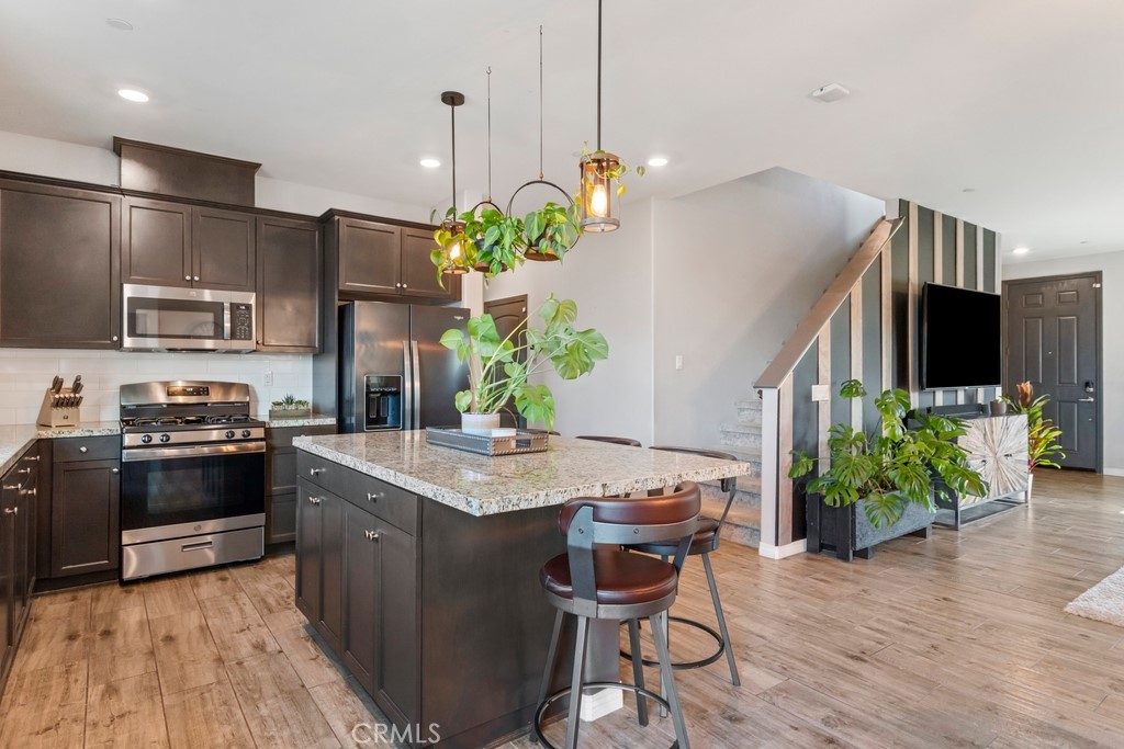 1148 Little Leaf Street Calimesa, CA 92320 - Photo 4 of 31 a kitchen with stainless steel appliances kitchen island granite countertop a stove a sink and a refrigerator