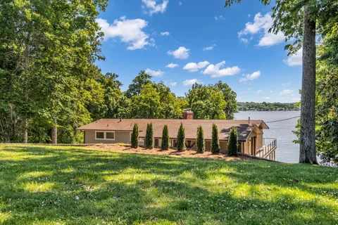 a view of a house with a yard deck and a patio