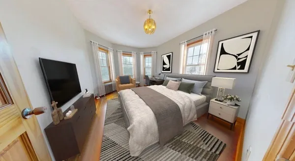 a bedroom with a bed and a flat tv screen on dresser