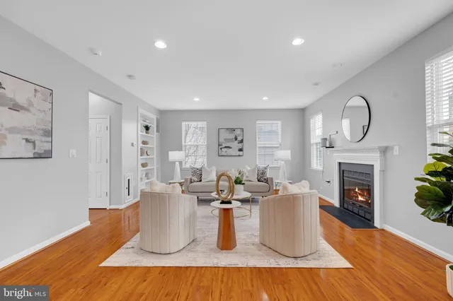 a living room with furniture a fireplace and potted plants