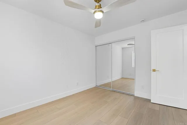 an empty room with a fan & a ceiling fan